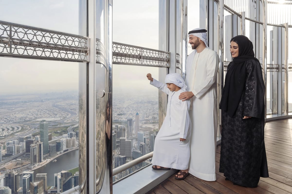 A family at the window of Level 124 with Downtown Dubai and the canal far below