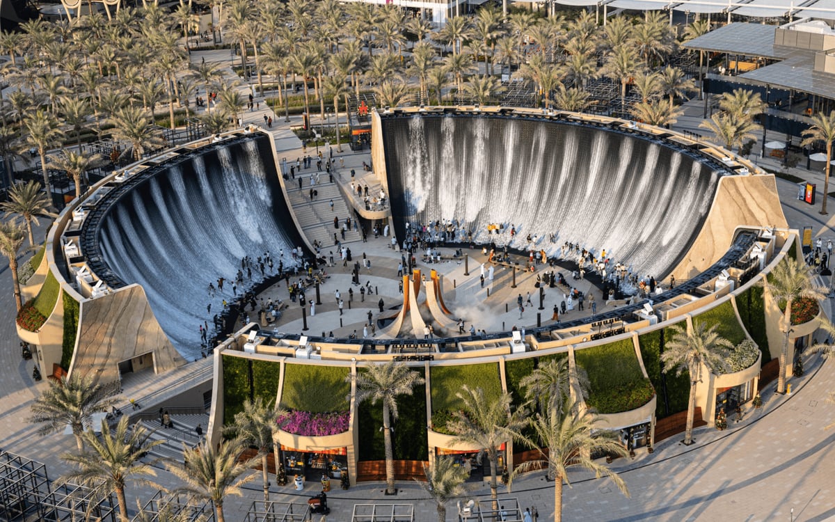 Aerial view of the Surreal water feature's cascading walls among palm-lined walkways