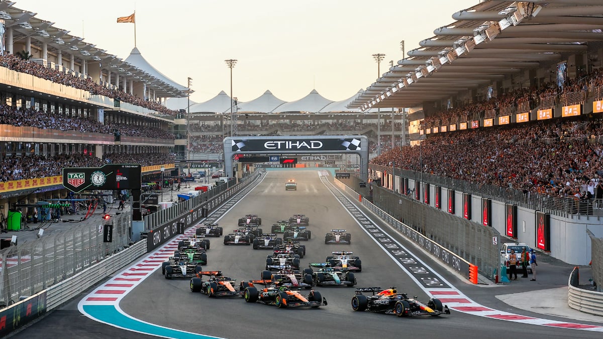 Formula 1 cars launching off the grid under the Etihad gantry between packed grandstands