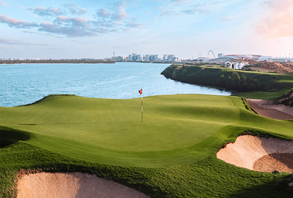 A flag on a green edged by deep bunkers above the water