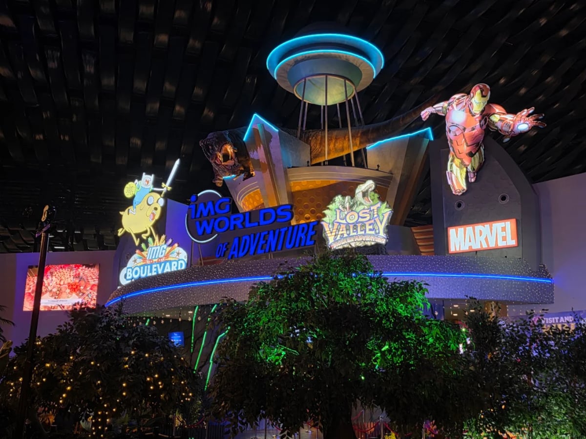 The IMG Worlds of Adventure gateway lit at night with Marvel and Cartoon Network heroes