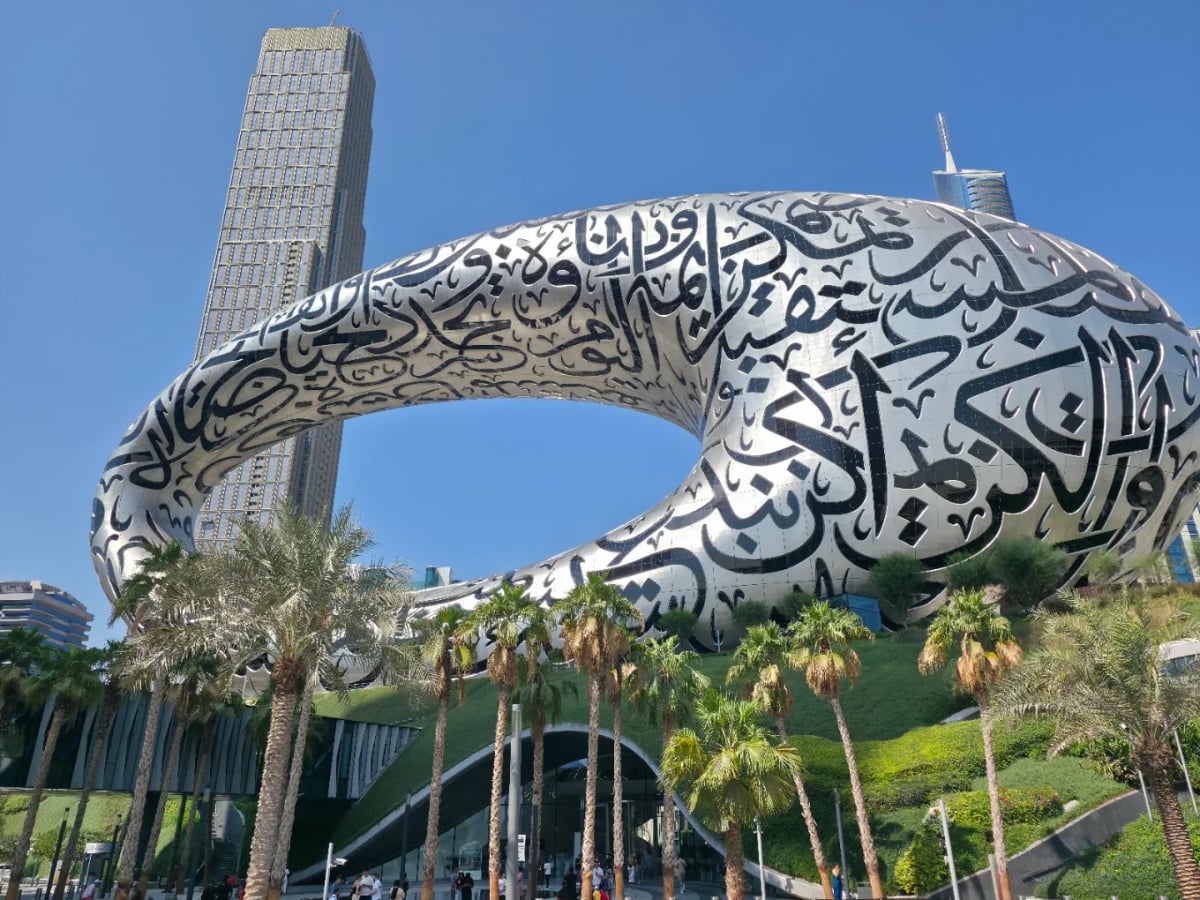 The Museum of the Future, a steel torus wrapped in Arabic calligraphy, among palm trees on Sheikh Zayed Road