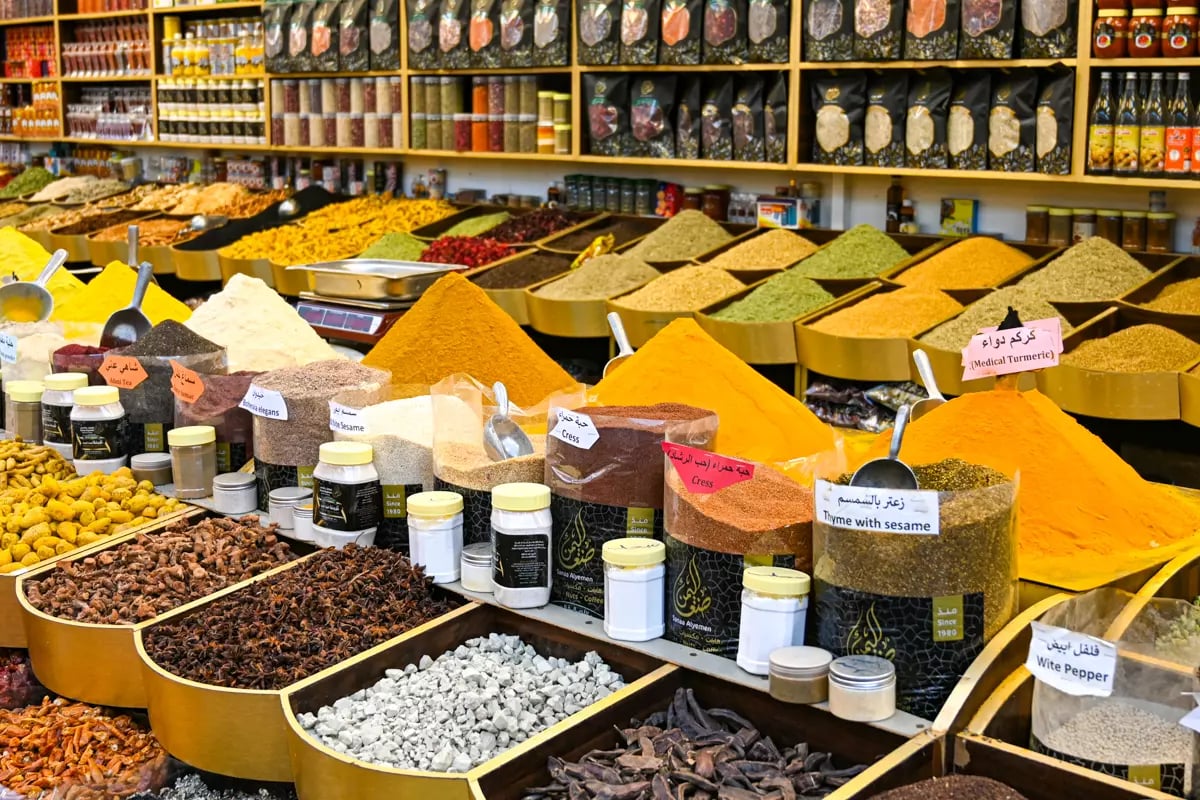 Trays of saffron, cardamom, turmeric and dried herbs piled up on shelves in a Deira spice shop