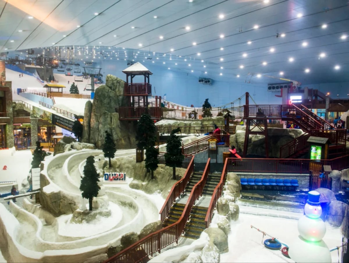 The Snow Park's tubing runs, chalets and fir trees under the indoor ceiling
