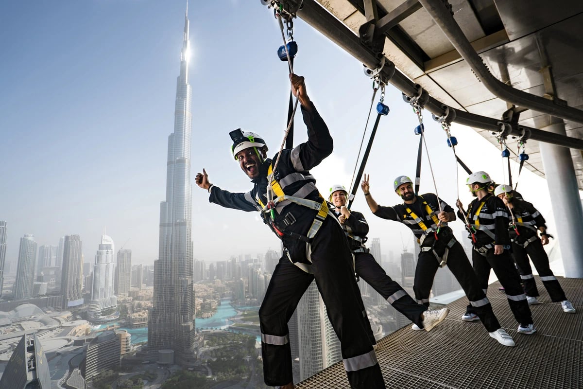 Guests in harnesses leaning out from the Edge Walk with Burj Khalifa behind