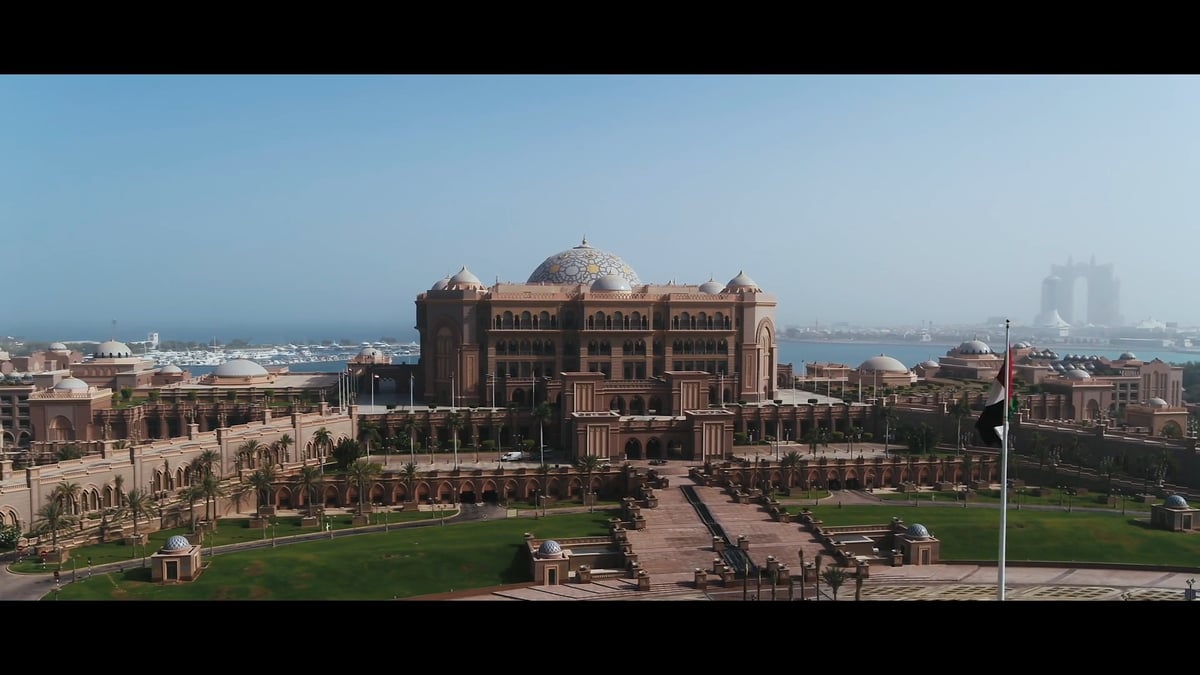 Aerial views of the palace, beach and skyline, the pool, a boat ride, and guests dining and relaxing in the suites.