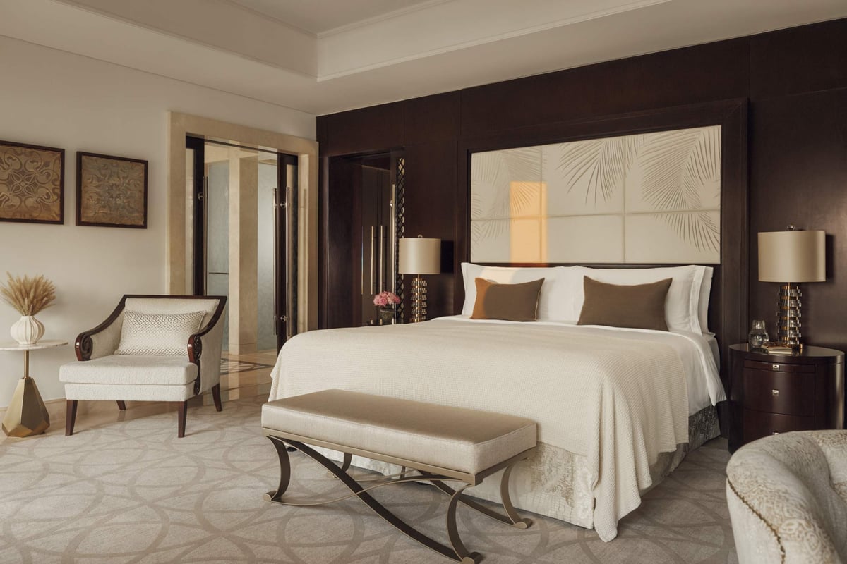 Two-Bedroom Villa, second bedroom with a king bed, bench, armchair and lamps, at One&Only The Palm.