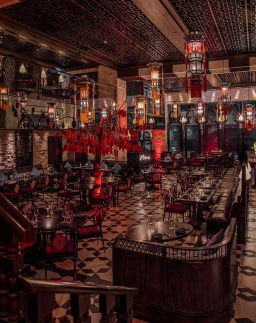 Dark lacquered booths and tables beneath red lanterns and carved wooden screens