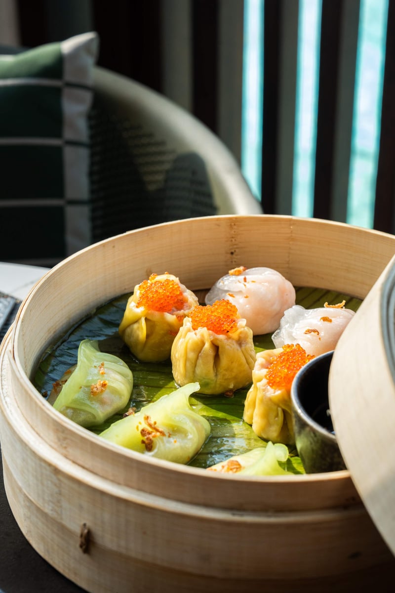 Dumplings topped with roe in a bamboo steamer on a banana leaf